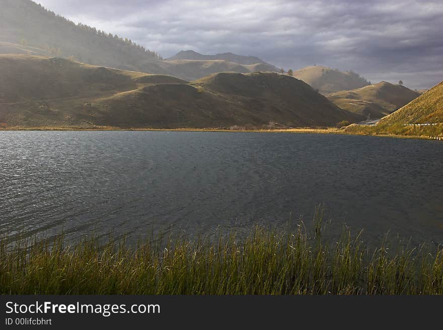 Mountain lake in the Swiss Alpes in cloudy autumn day. . Mountain lake in the Swiss Alpes in cloudy autumn day