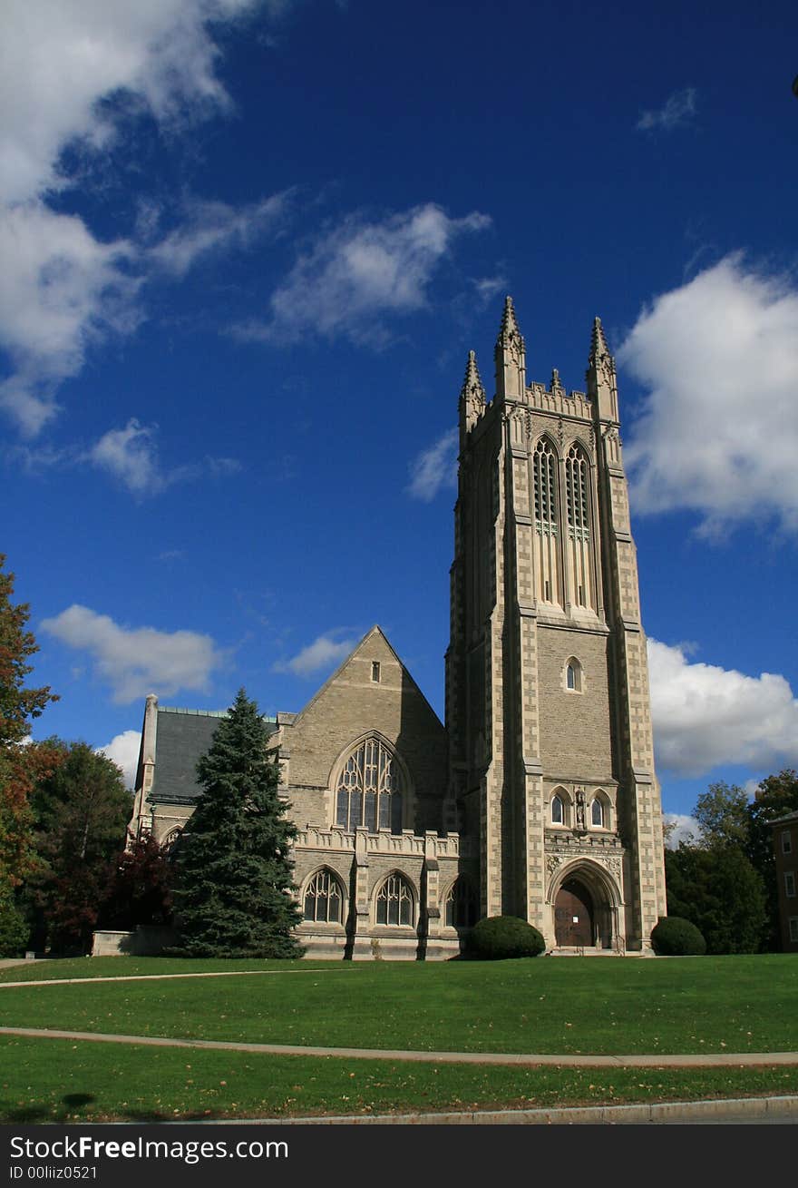 Gothic Cathedral in fall with grassy lawn blue sky and clouds