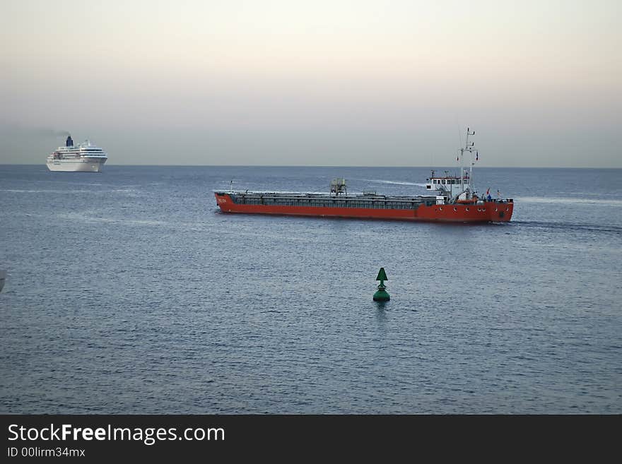 Industrial ship leaving the harbor of Nice at sunset. Navigation in channel. Industrial ship leaving the harbor of Nice at sunset. Navigation in channel