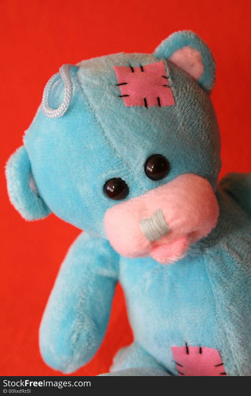 Blue teddy bear against dark orange background. Blue teddy bear against dark orange background