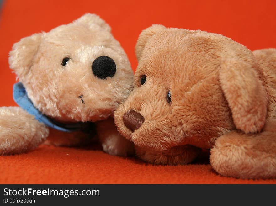 Teddy bears against dark orange background. Teddy bears against dark orange background