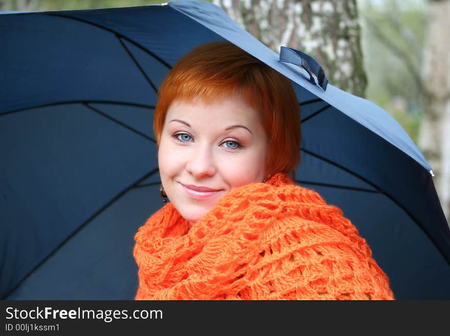 Young red-haired woman in red scarf with umbrella. Young red-haired woman in red scarf with umbrella