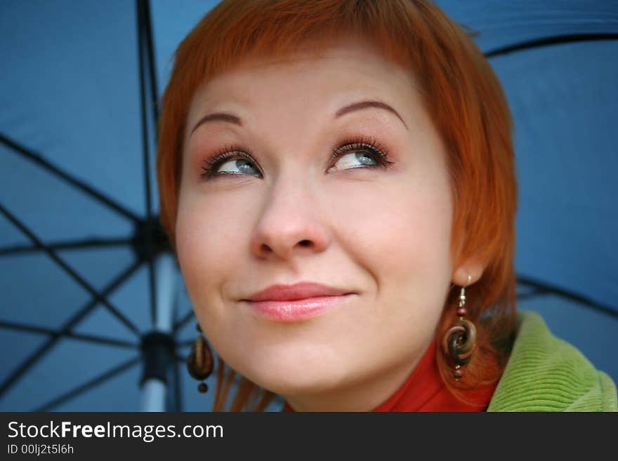 Young red-haired woman in red scarf with umbrella. Young red-haired woman in red scarf with umbrella