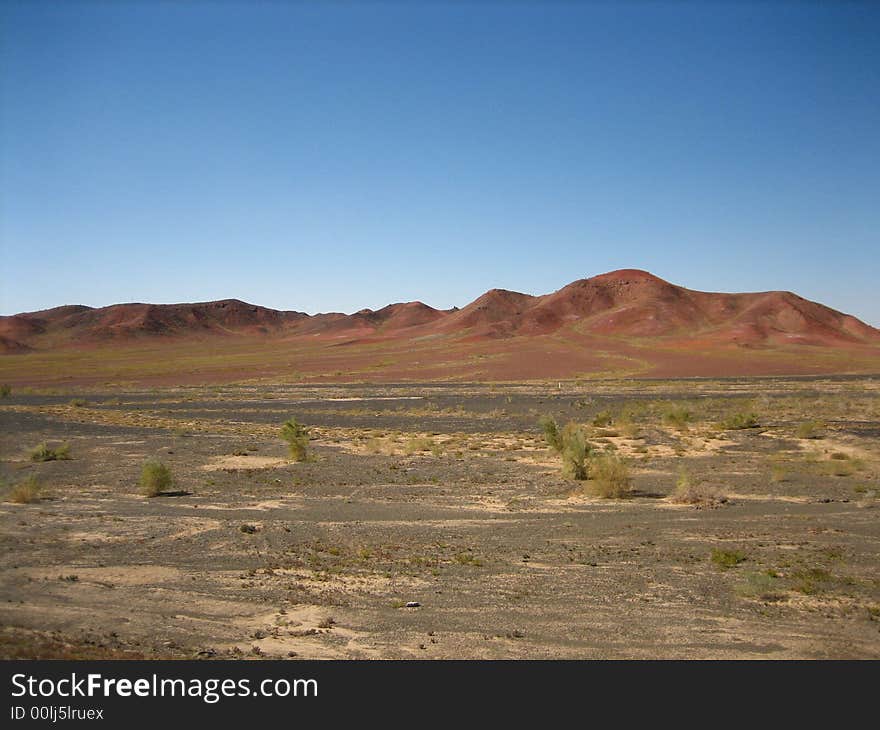 This photo was taken in Xinjiang China, and the moutain's name is Burning Moutain. The sky is very blue and red moutain is standing in the Gobi. This photo was taken in Xinjiang China, and the moutain's name is Burning Moutain. The sky is very blue and red moutain is standing in the Gobi.