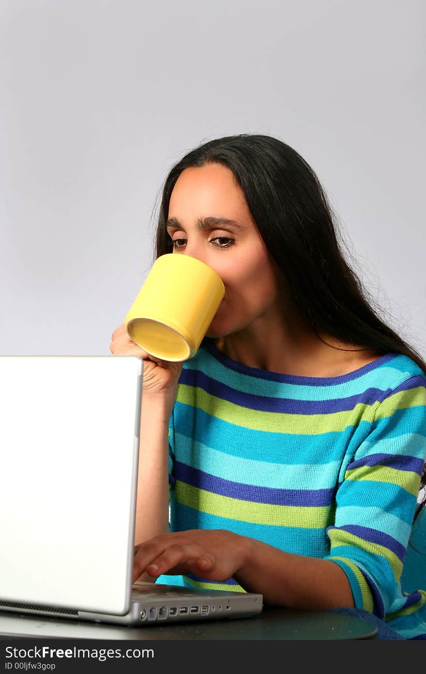 Digital photo of a woman surfing in the internet and drinking a cup of coffee. Digital photo of a woman surfing in the internet and drinking a cup of coffee.