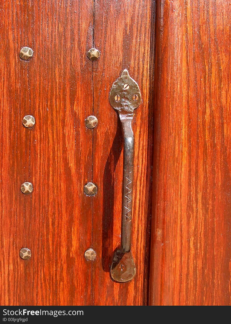 An antique brass door handle and antique brass nails.