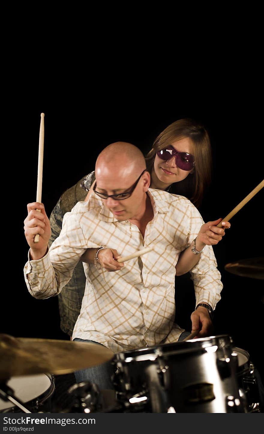 Shot of woman bugging drummer playing over black backdrop. Shot of woman bugging drummer playing over black backdrop