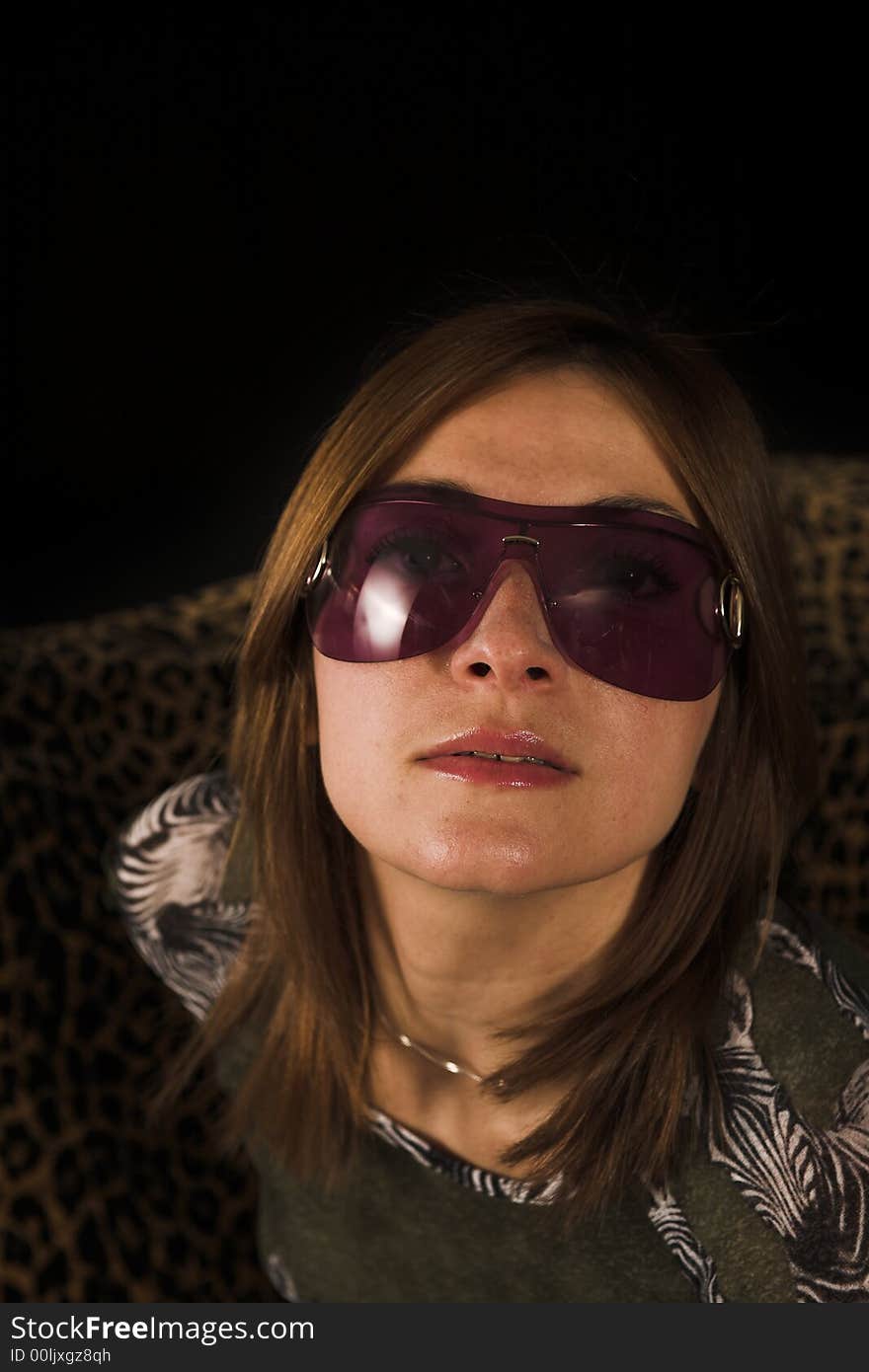 Woman portrait shot on couch on black backdrop