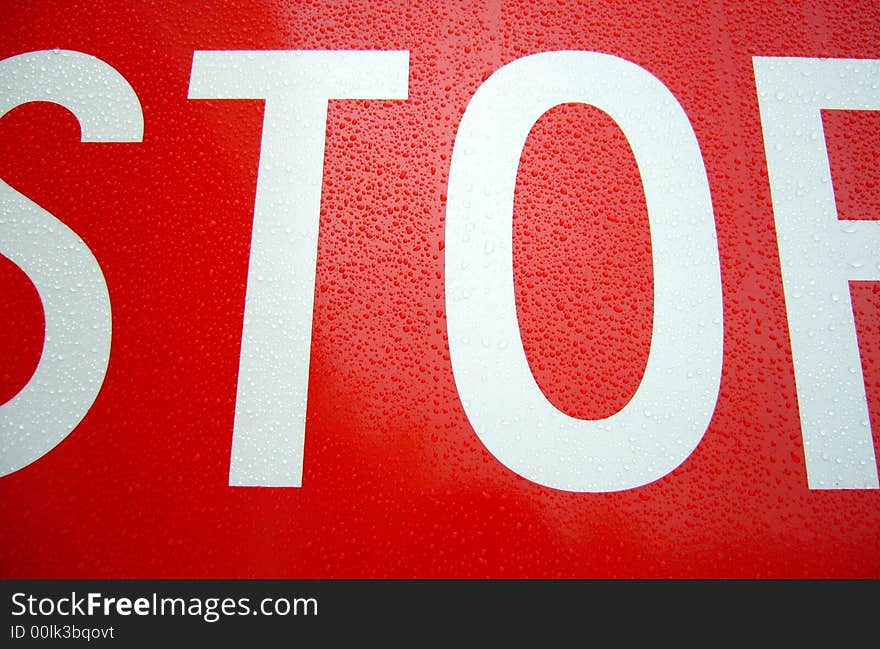 A stop sign with some dew drops on it