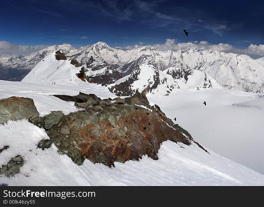 A panoramic view on Alpes snow mountains from one of the tops over clouds. A panoramic view on Alpes snow mountains from one of the tops over clouds