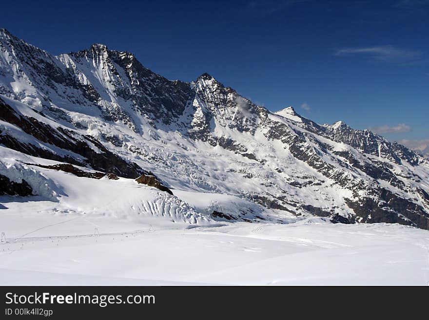 A panoramic view on Alpes snow mountains from one of the tops over clouds. A panoramic view on Alpes snow mountains from one of the tops over clouds