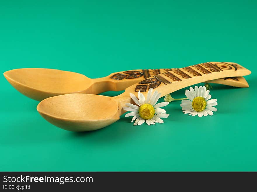 Wooden  spoons and  flowers on a green  background