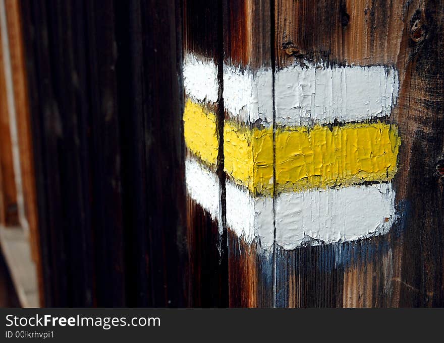 Three colours tourist track sign on the wooden wall - close-up. Three colours tourist track sign on the wooden wall - close-up