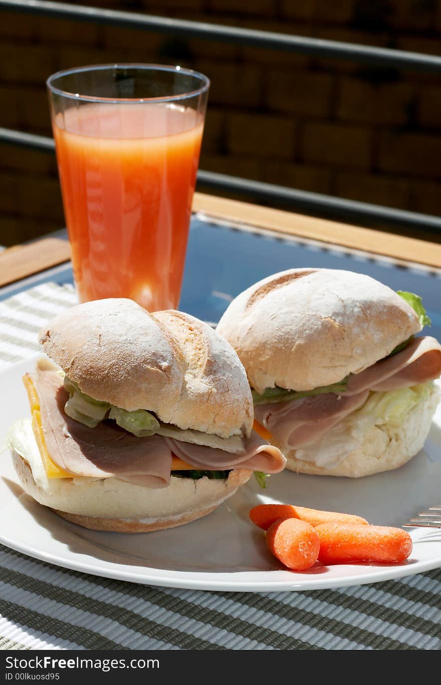 Ham and cheese sandwich on portuguese rolls served with juice