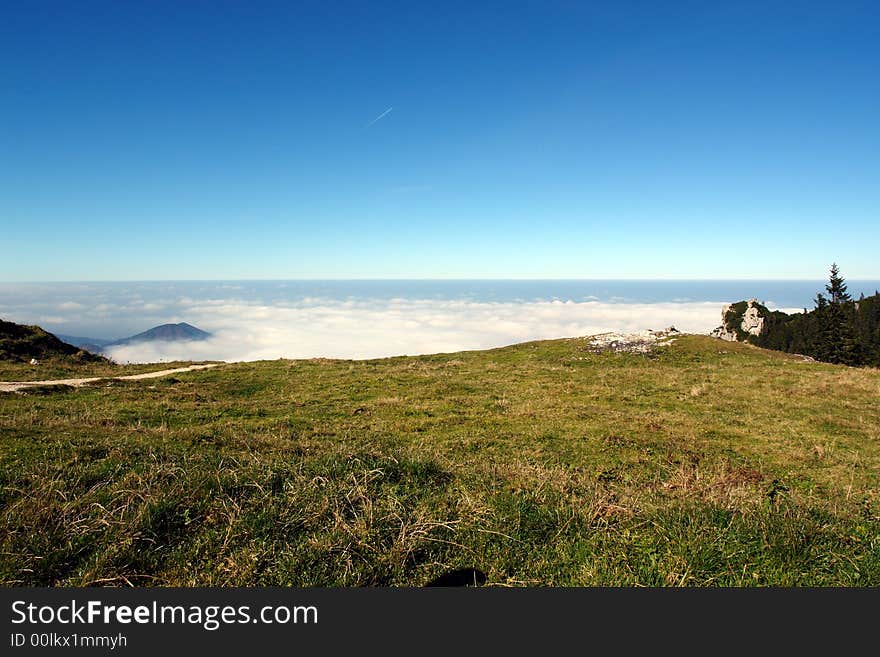 Alpes, Bavaria, Germany . Sight from the Kampenwand Mountain ( Height 1665 m ).White clouds below the peak of Mountain.October 2007 . Alpes, Bavaria, Germany . Sight from the Kampenwand Mountain ( Height 1665 m ).White clouds below the peak of Mountain.October 2007 .