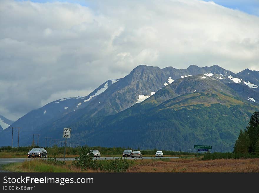 Alaska Highway with mountains in background.