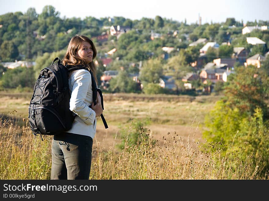 Young woman with backpack standing on the road