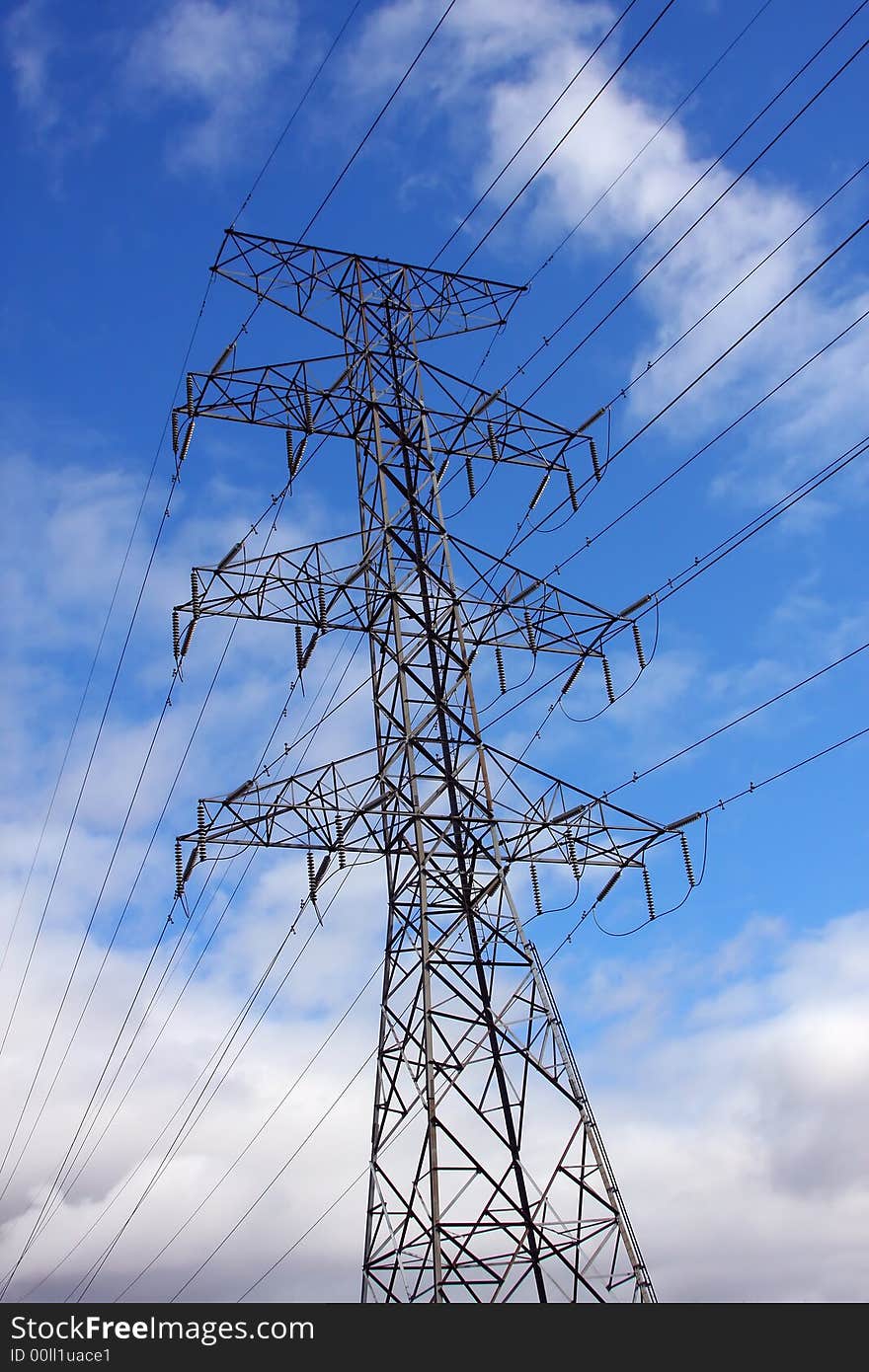 High tension lines, tower and clouds form patterns in the sky. High tension lines, tower and clouds form patterns in the sky