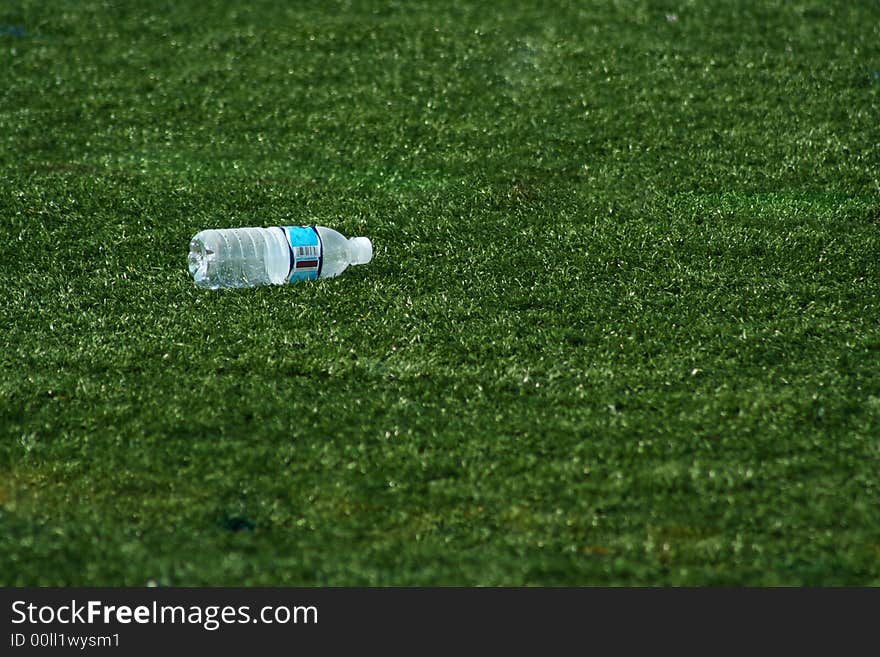 A Empty water bottle on green grass. A Empty water bottle on green grass