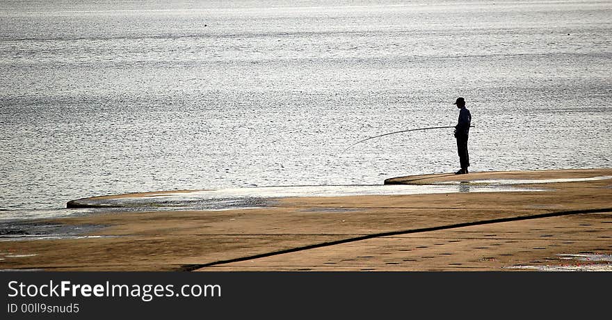 A man fishing on the beach. A man fishing on the beach.