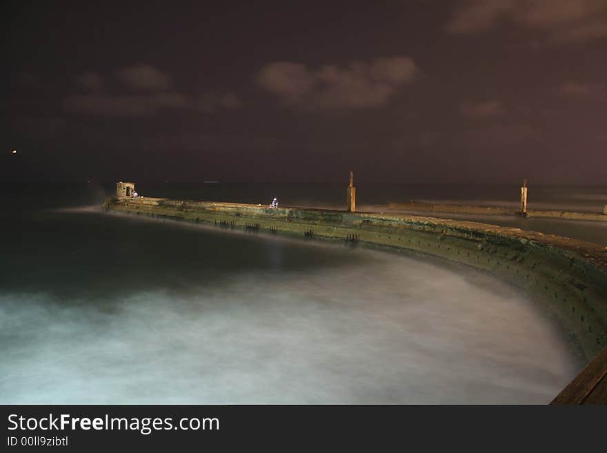 Lighthouse and jetty by night, tel aviv, israel