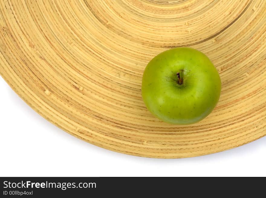 Green apple on a bamboo plate