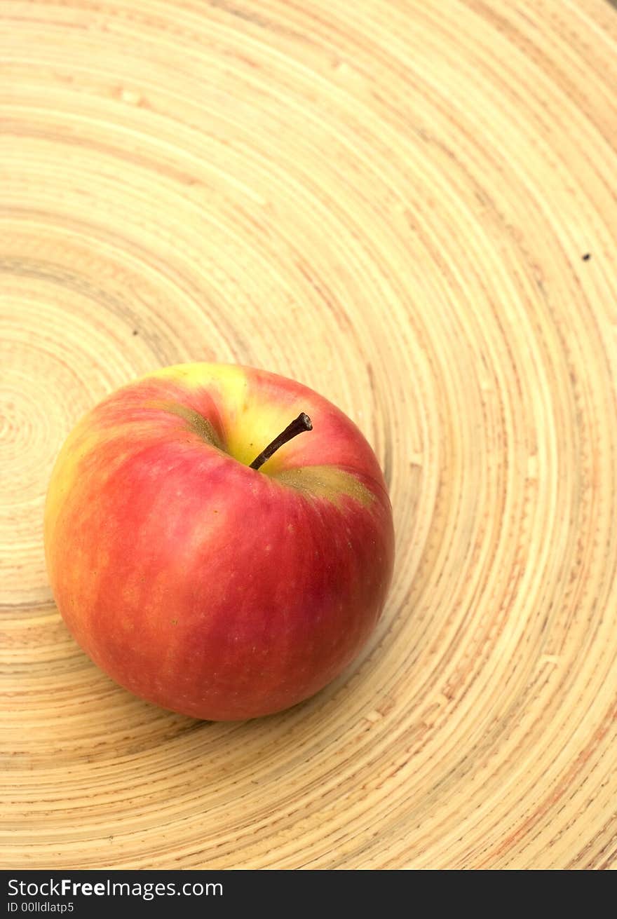 Red apple on a bamboo plate