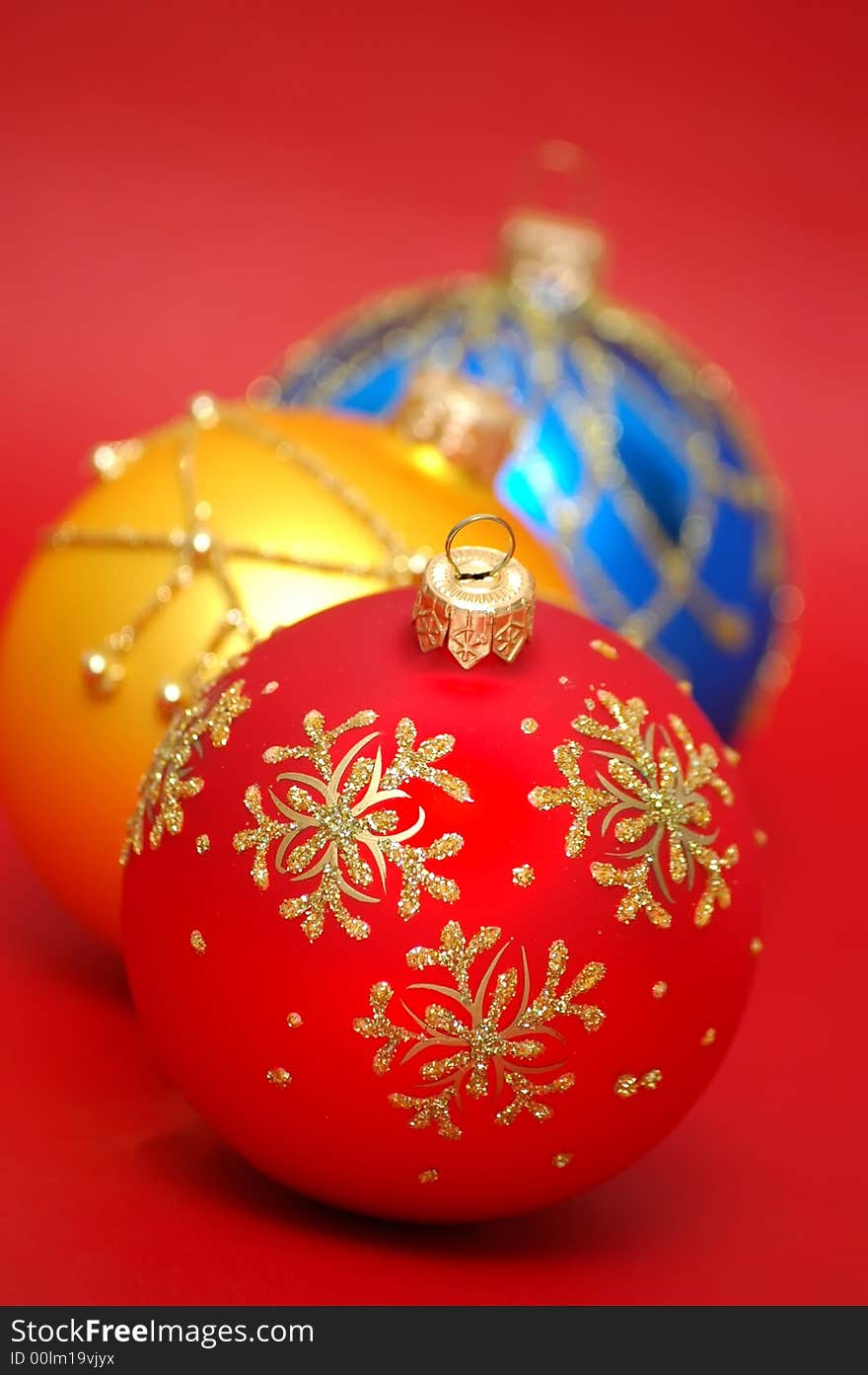 Three colorful christmas balls on a red background