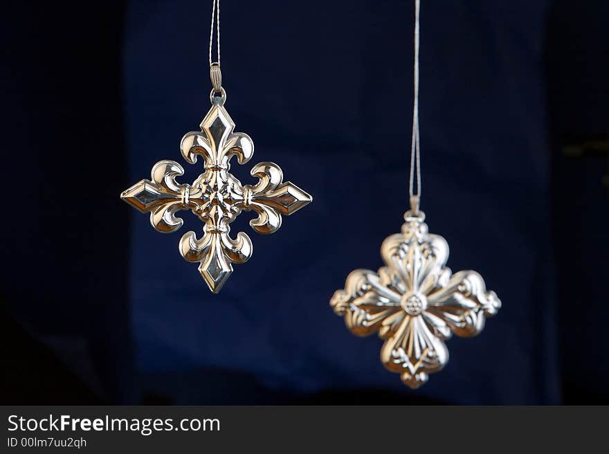 Silver crosses Christmas decorations isolated on blue/black background