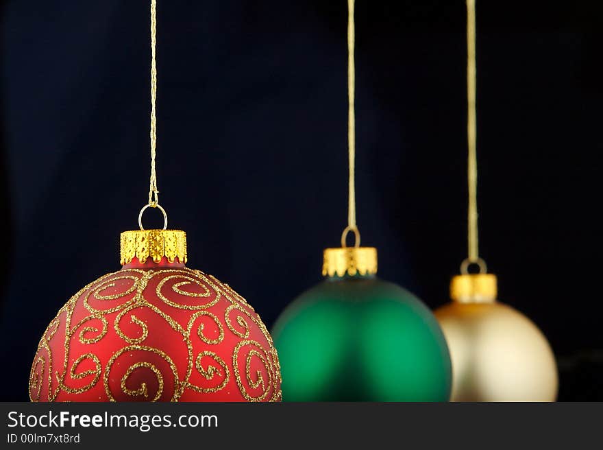 Red, green and gold Christmas decorations isolated on blue/black background