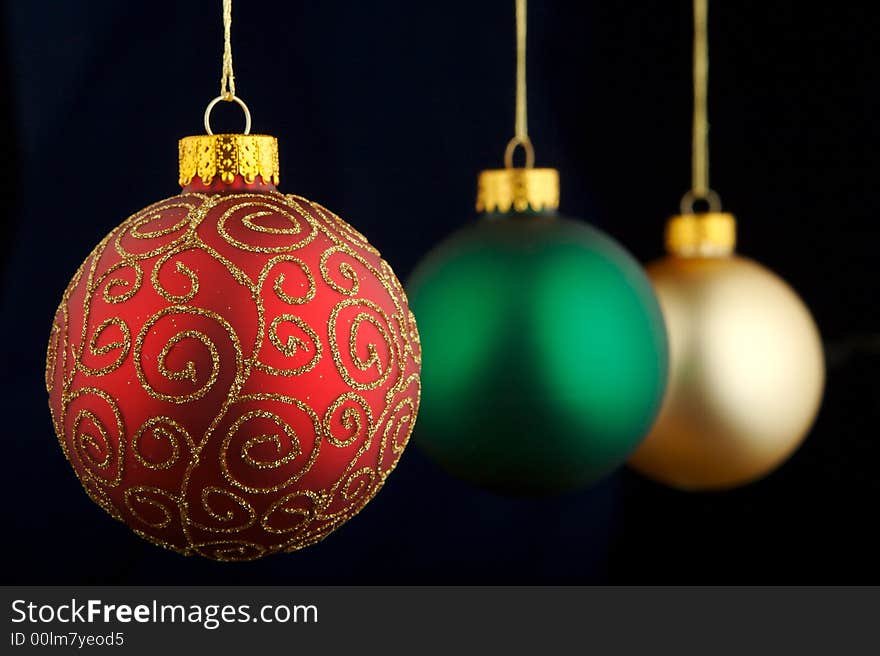 Red, green and gold Christmas decorations isolated on blue/black background