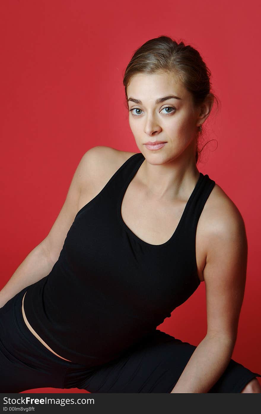 Young lady doing yoga exercise on red back ground