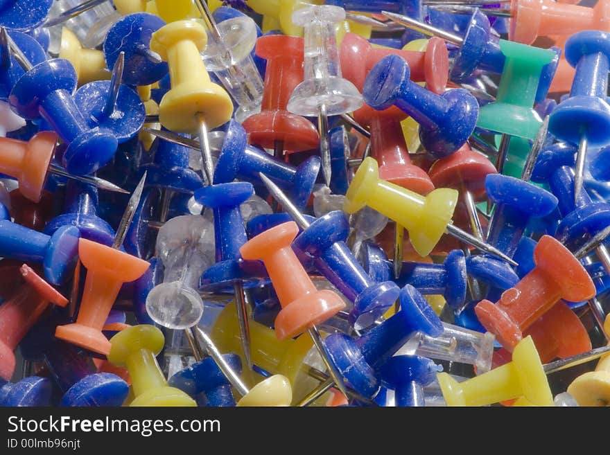 A closeup of a pile of colorful push pins.