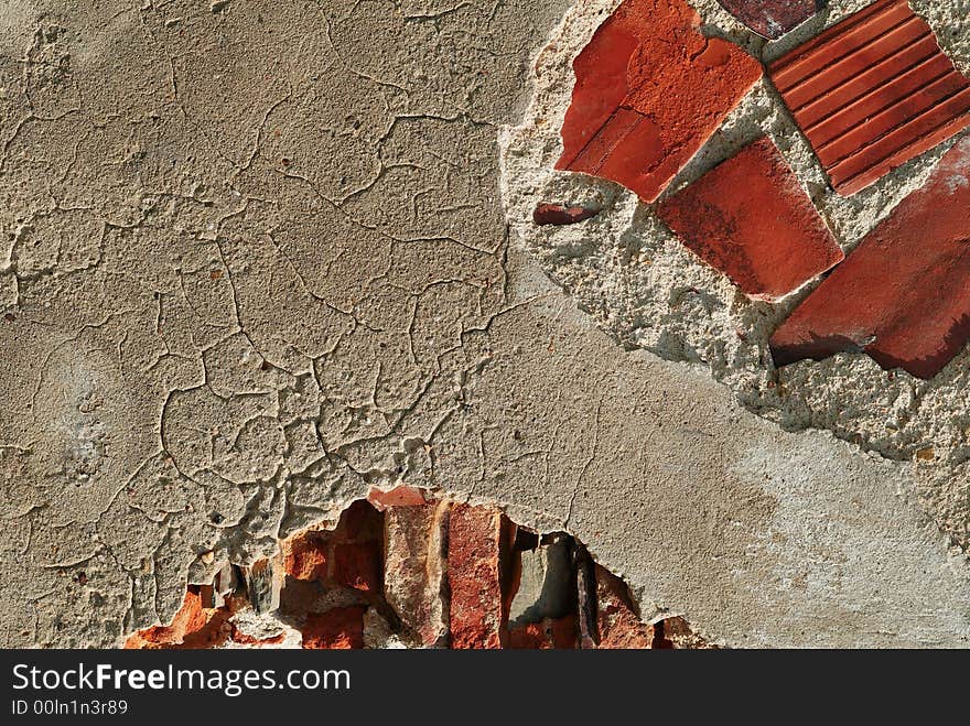 Fragment of a brick wall with the broken plaster. Fragment of a brick wall with the broken plaster