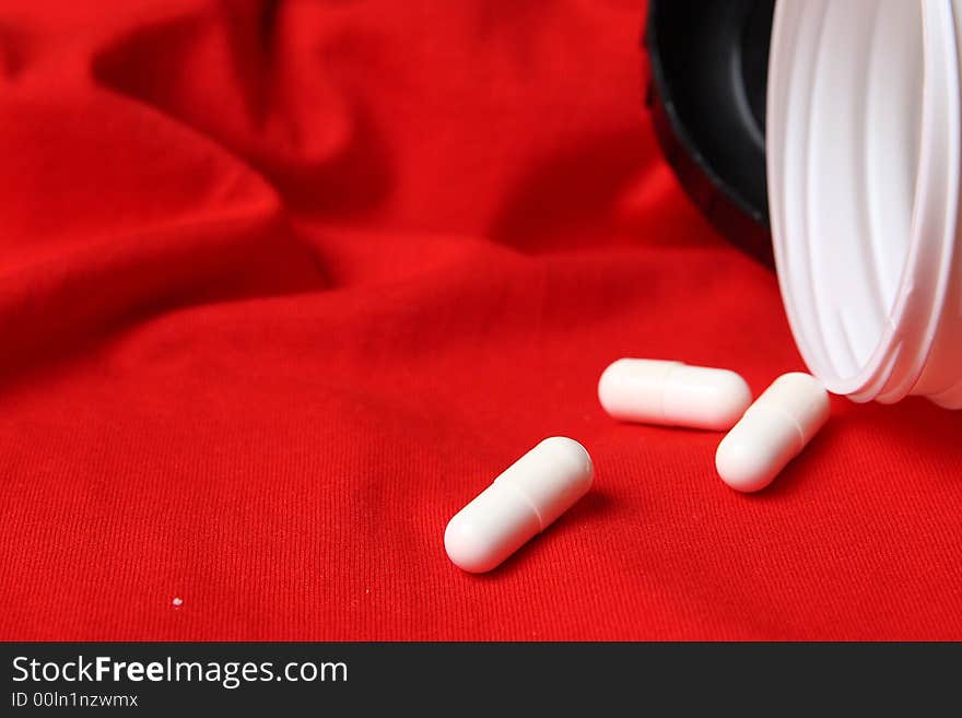 White pills and red background