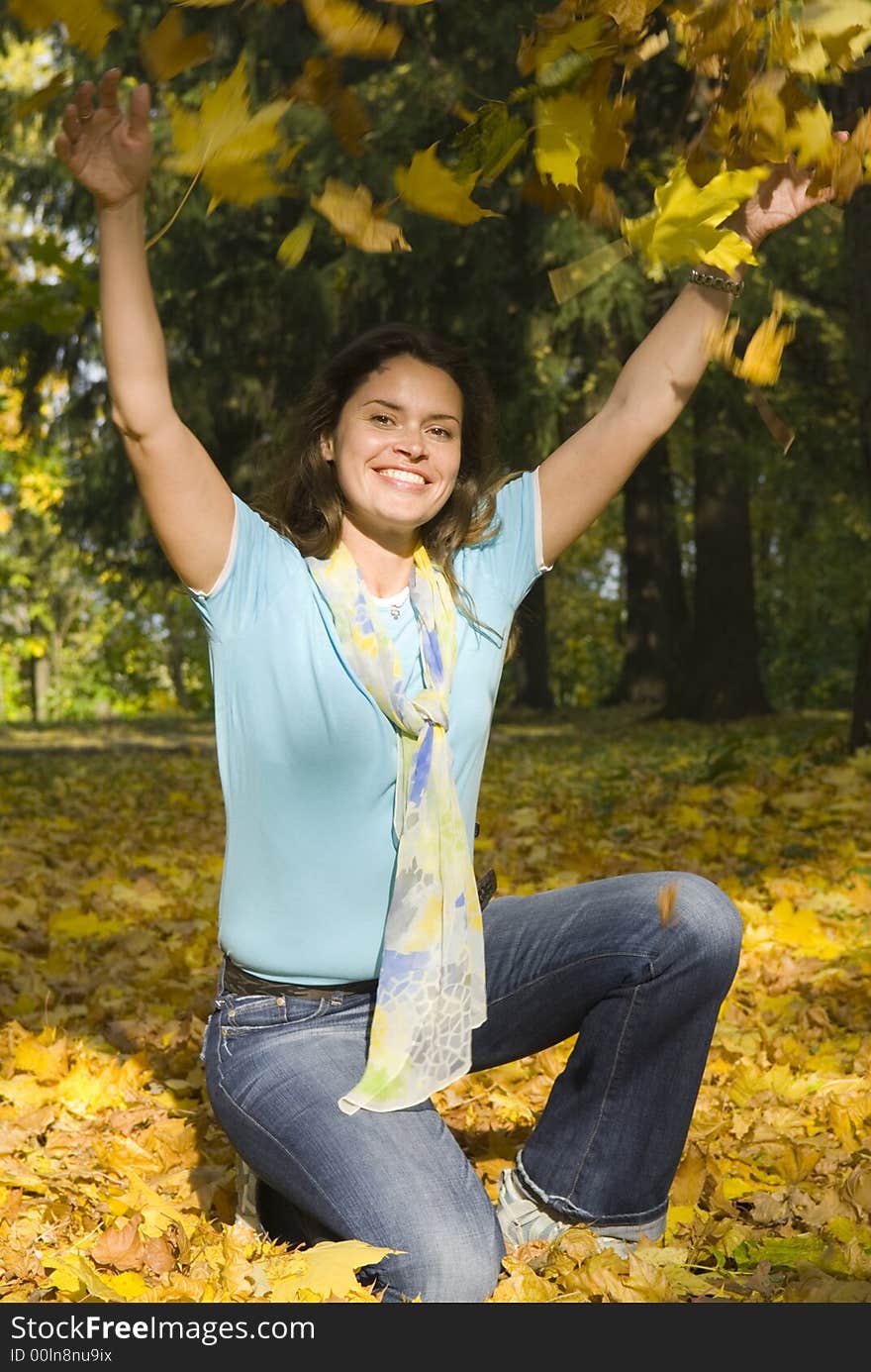 Beautiful woman in blue shirt with yellow maple leaves. Beautiful woman in blue shirt with yellow maple leaves