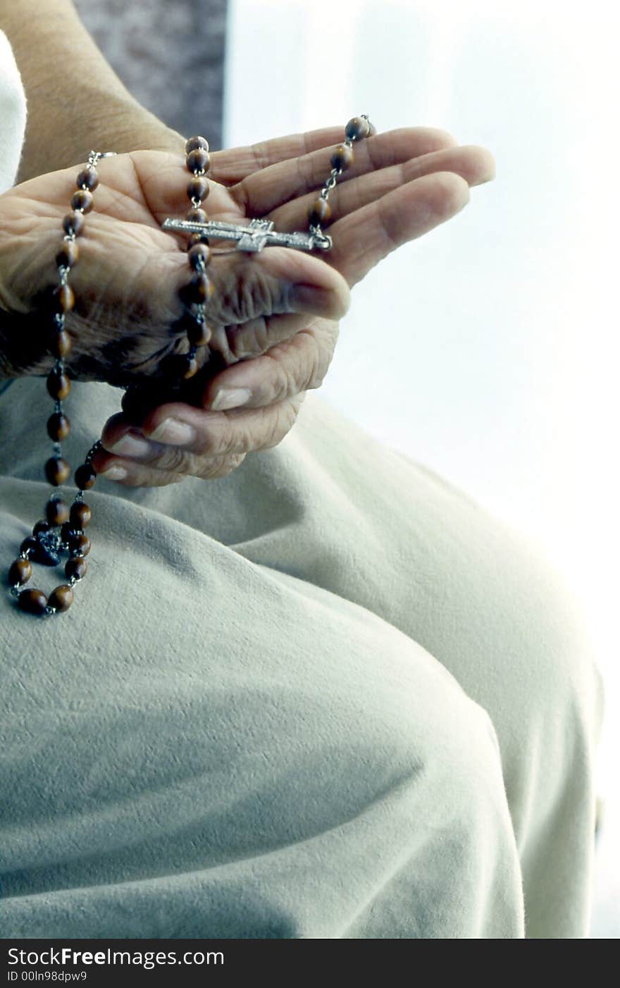 Hands holding rosary in meditation.