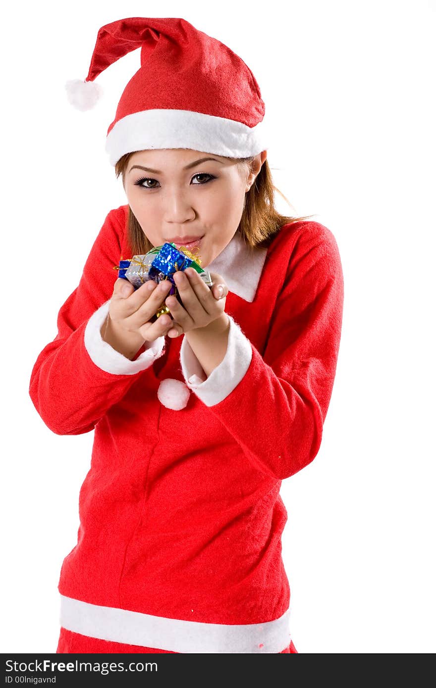 cute young woman in santa costume blowing a handful of tiny colorful gifts. cute young woman in santa costume blowing a handful of tiny colorful gifts