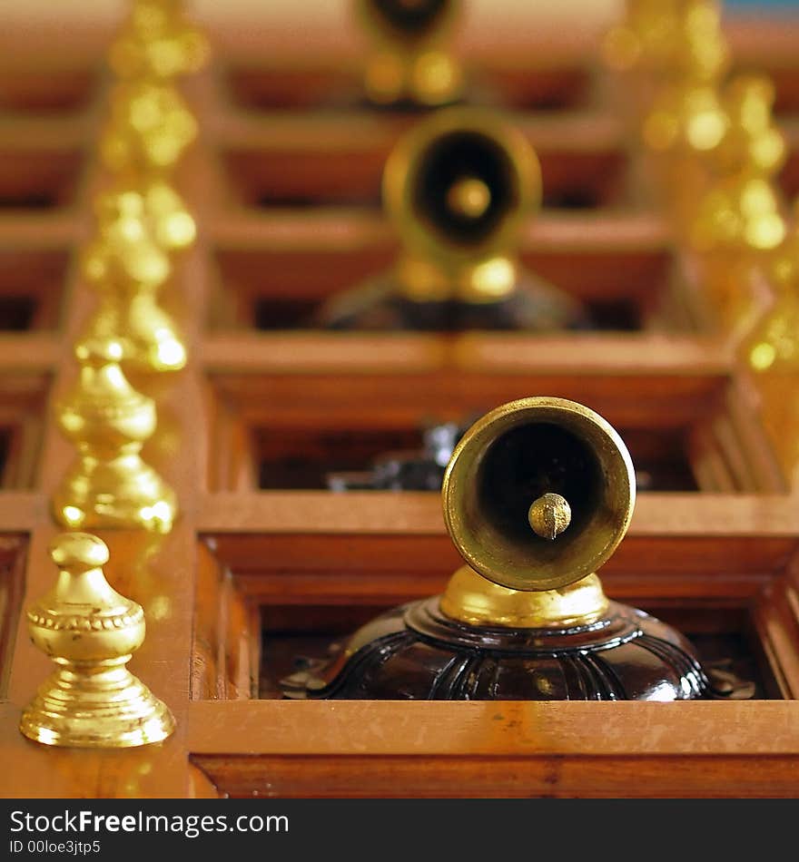 Tiny bells adorning the wooden door of an Indian temple seen from bottom up with shallow depth of field. Tiny bells adorning the wooden door of an Indian temple seen from bottom up with shallow depth of field