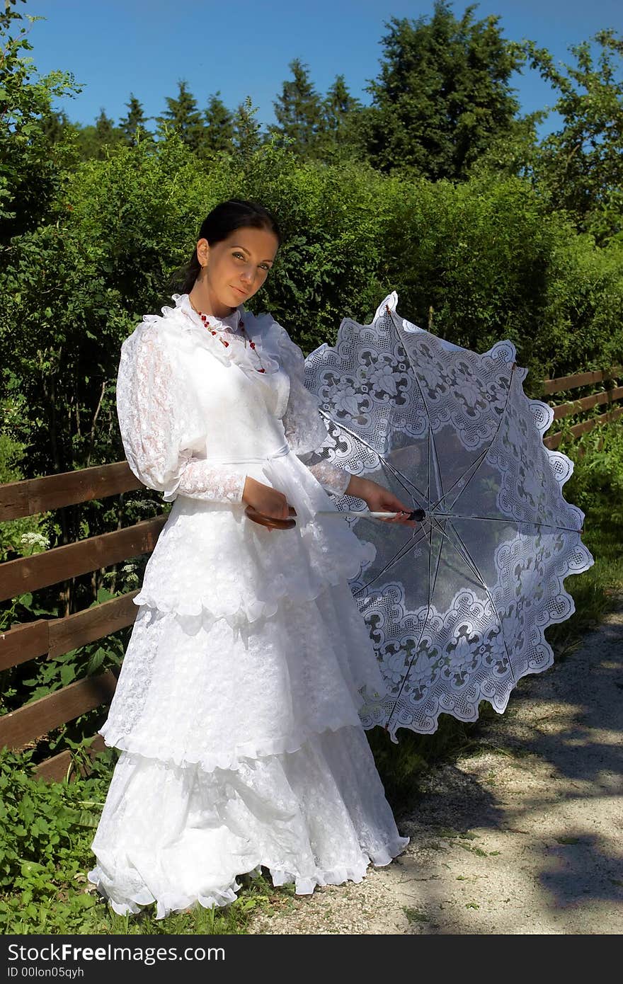 Beautiful young woman, in a white dress with umbrella