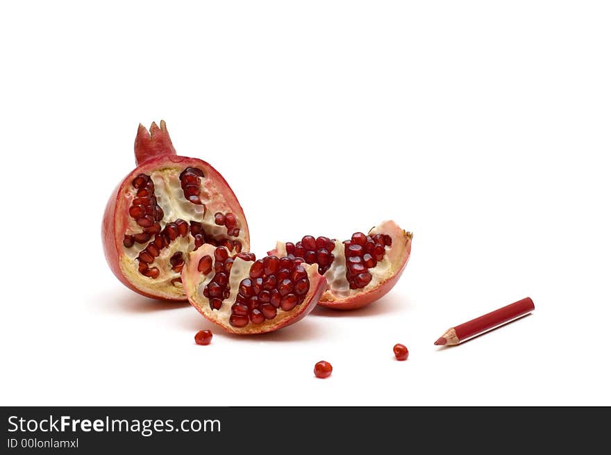 Broken pomegranate with grains and red pencil