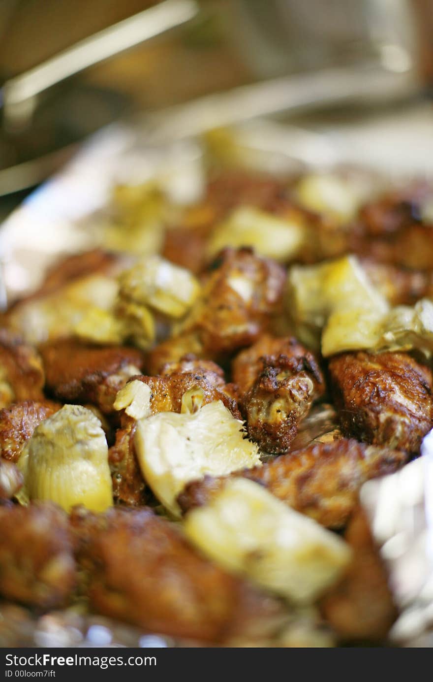 Close-up view of chicken wings and artichokes