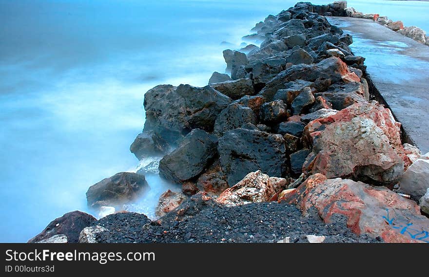 Landscape with rocks and blue sea in the evening