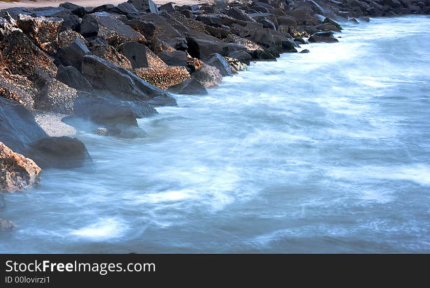 Landscape with rocks and blue sea in the evening