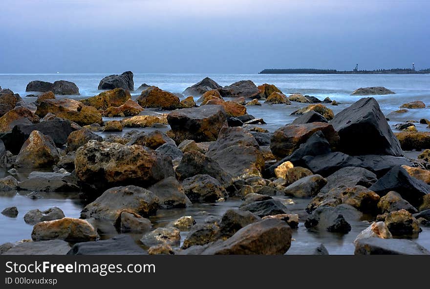 Landscape with rocks and blue sea in the evening