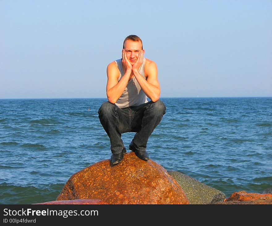 Young man sitting on a stone