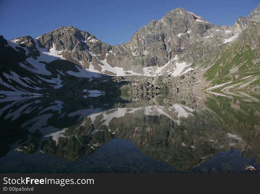 A reflection of mountains is in a lake