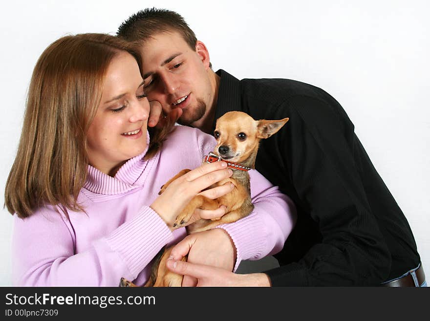 A young couple holding a tiny chihuahua. A young couple holding a tiny chihuahua