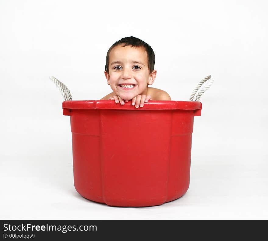 A young boy smiling in a tub. A young boy smiling in a tub