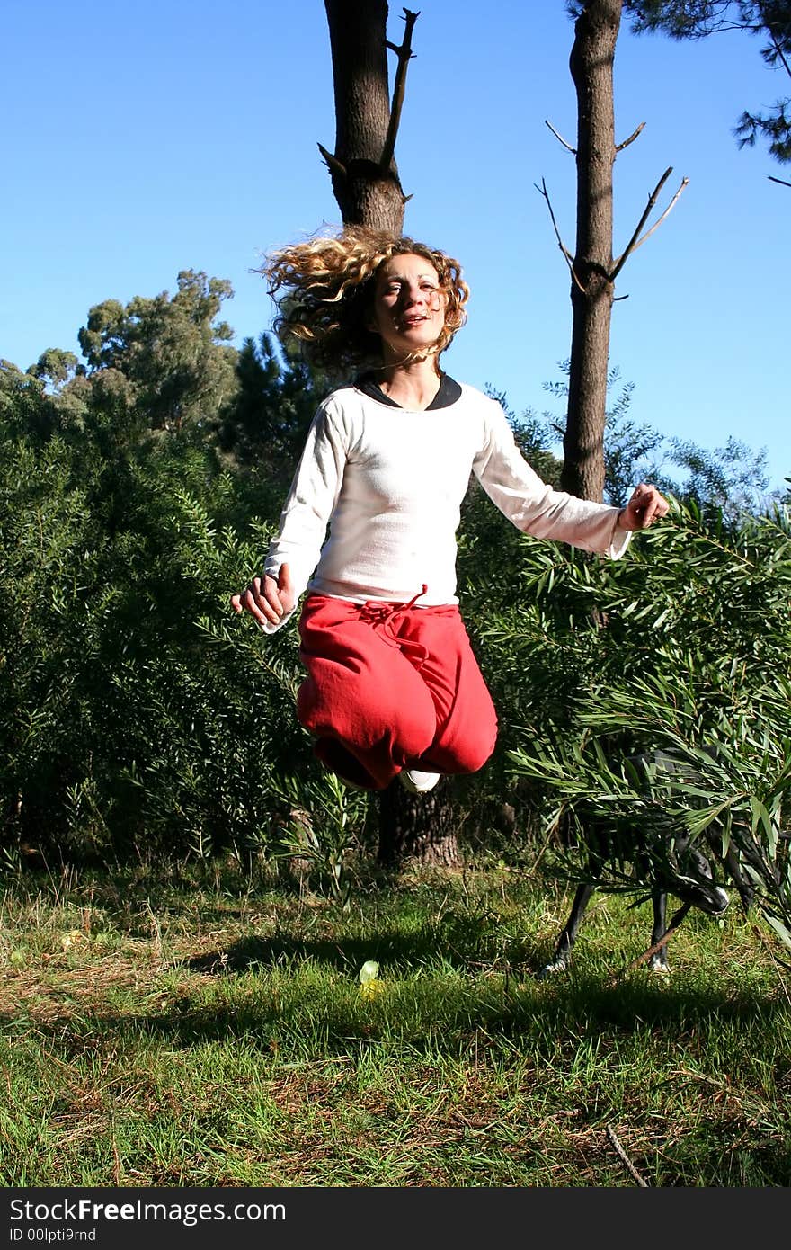 Digital photo of a woman jumping in a forest.